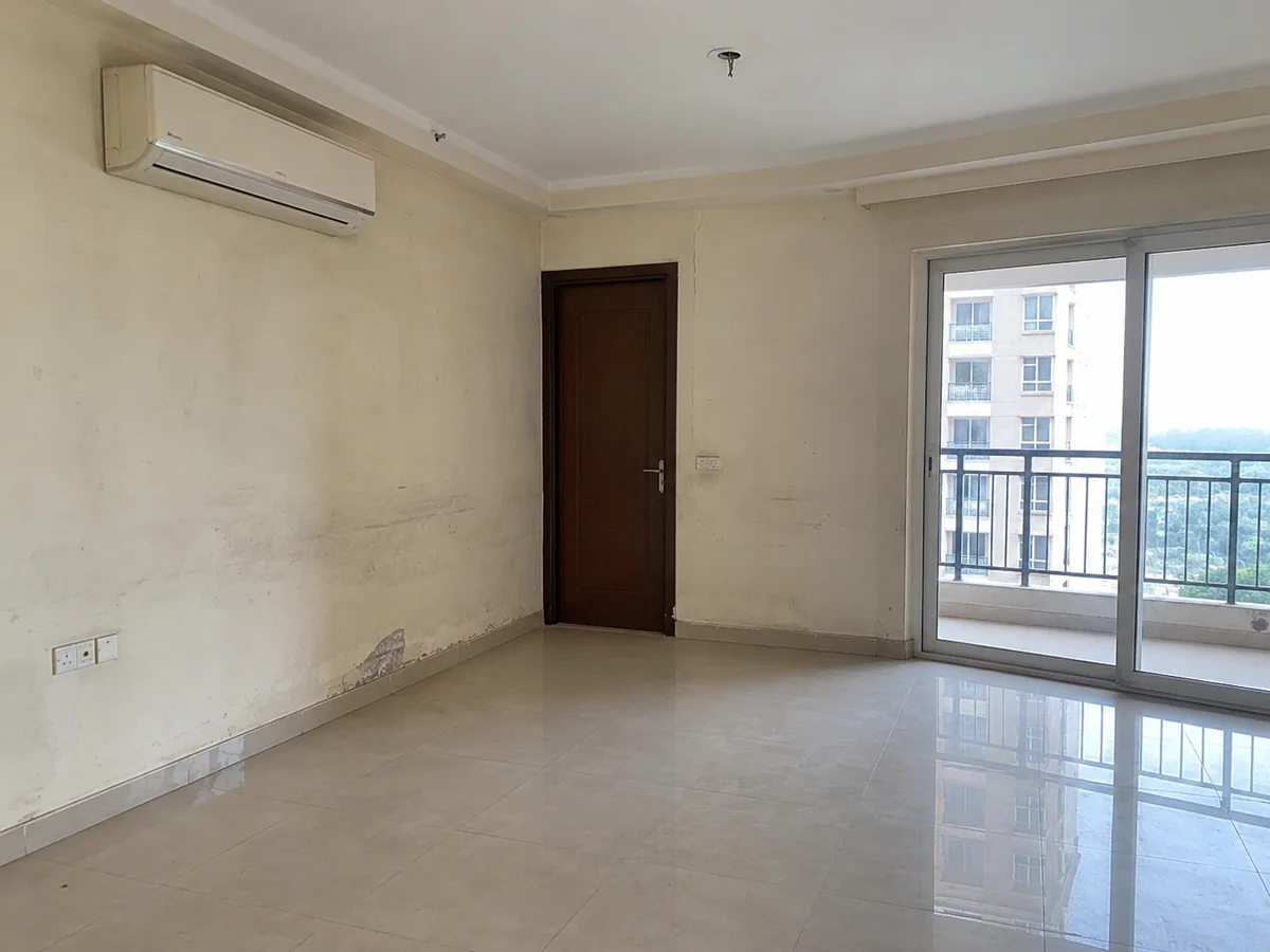Living room — stained, patchy walls repainted flat — before