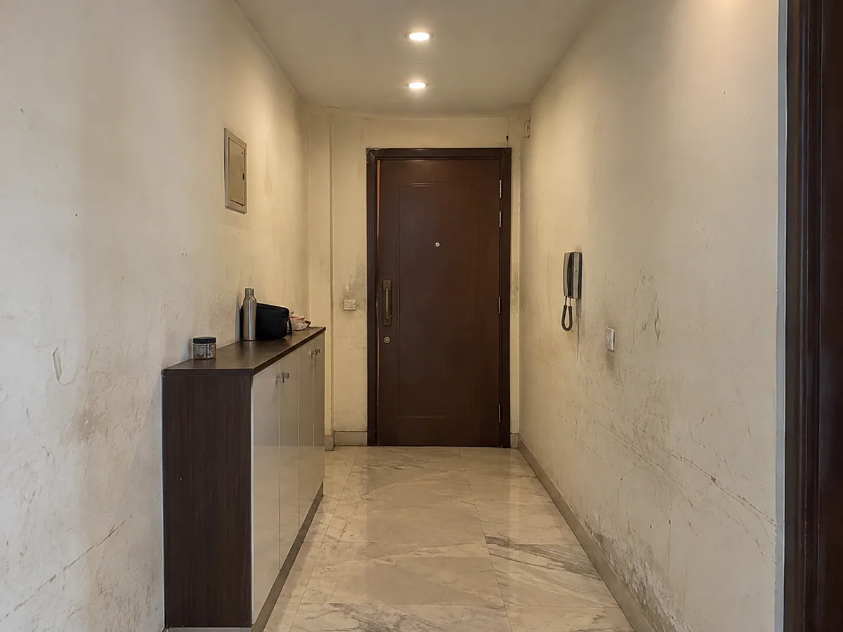 Entrance corridor — scuffed walls repainted two-tone — before