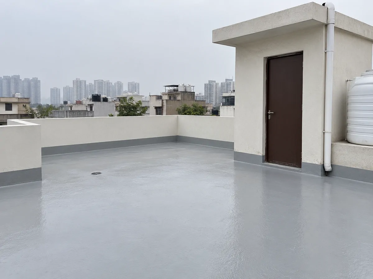 Terrace — cracked, ponding screed sealed under a coved membrane — after