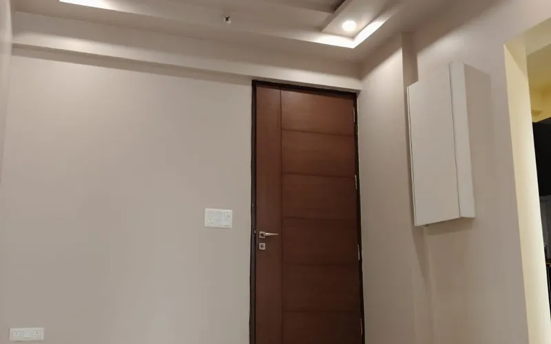 Freshly painted empty room with a wooden door, marble floor and ceiling fan
