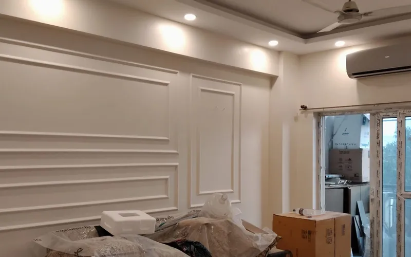 Living room with furniture wrapped in plastic sheeting before painting begins
