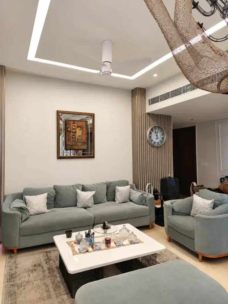 Living room with a cove-lit false ceiling, fluted slat feature wall and grey sofas